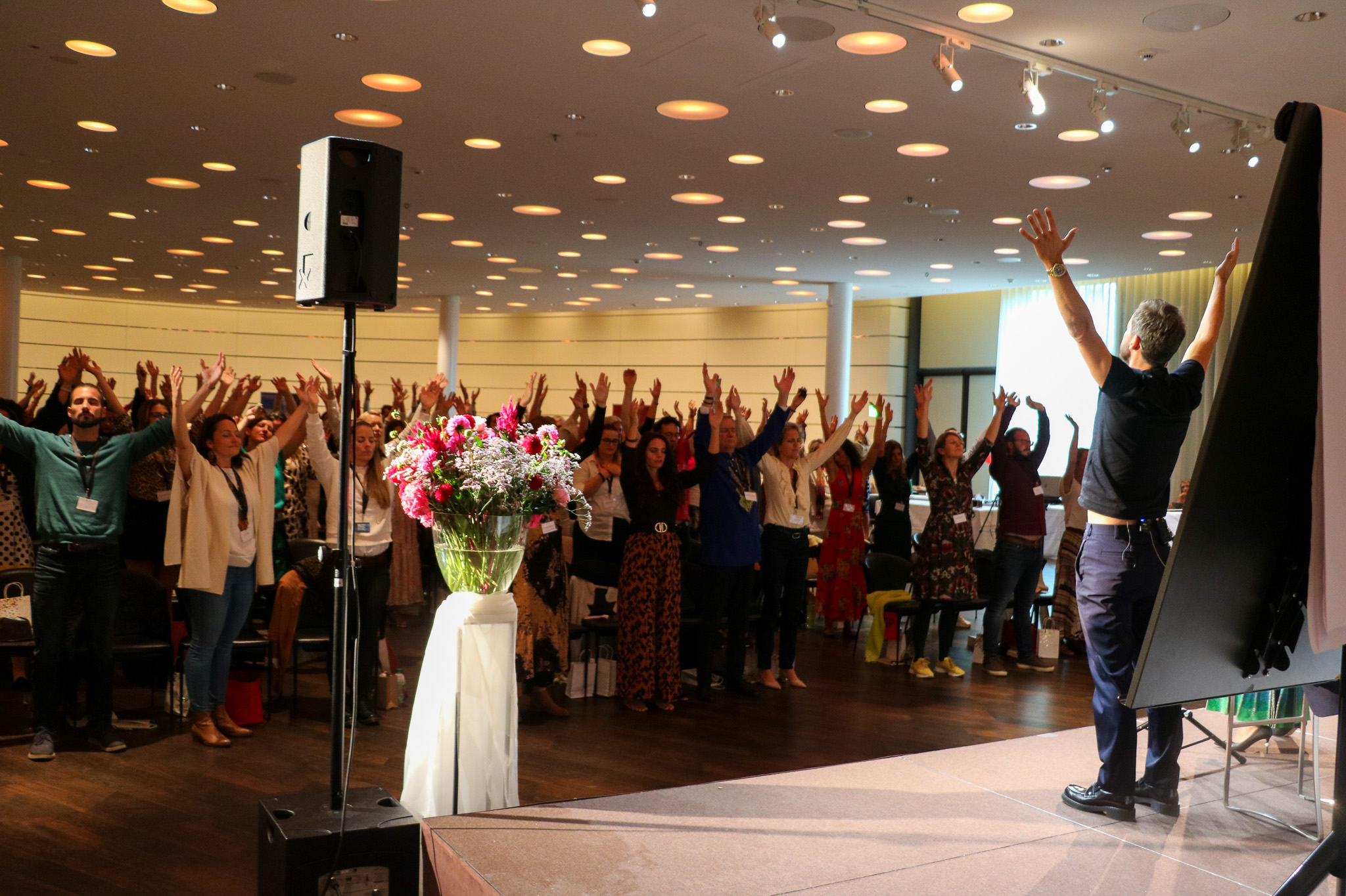 Audience raising their arms during a keynote