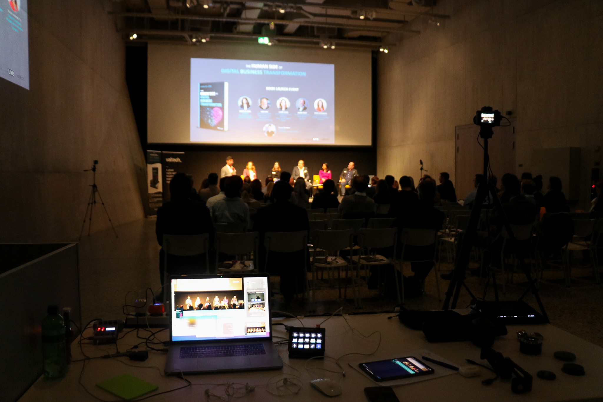 Dark event hall with the live stream running on a laptop