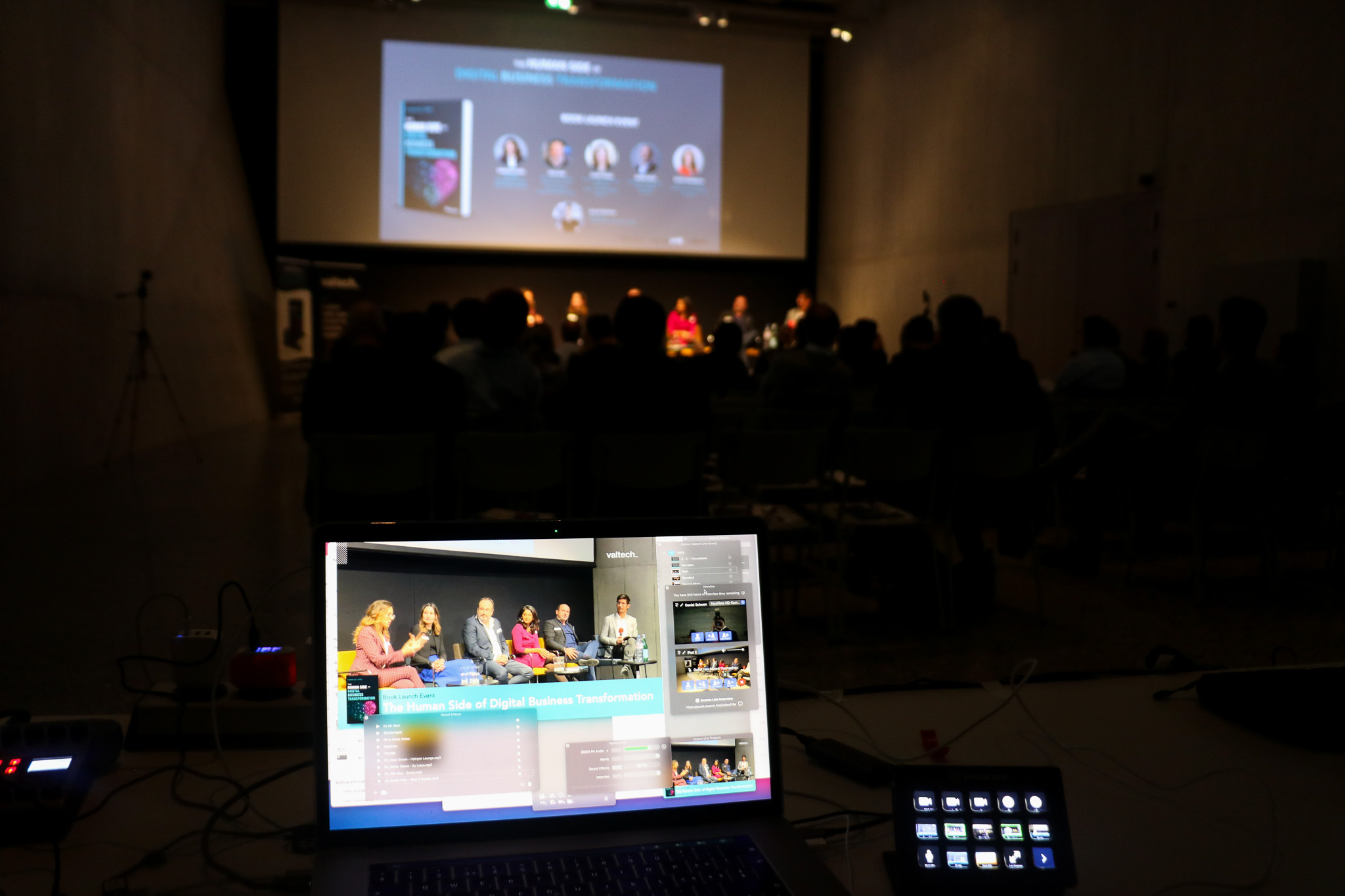 Streaming laptop and control deck in front of an empty stage before a book launch